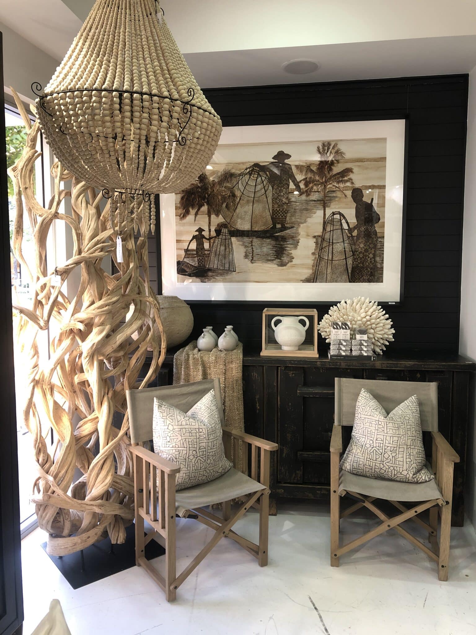 A large painting hanging in the center of a living room, surrounded by couches and a coffee table